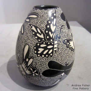 Sgraffito dragonfly and butterfly motif on a black and white jar