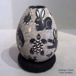 Sgraffito animal, insect and mesh motif on a black and white jar