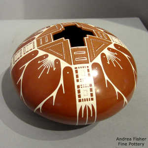 Sgraffito and painted geometric design on a red and white jar with a geometric opening
