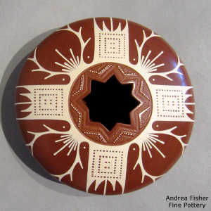 Geometric cut opening and a geometric design on a white on red jar