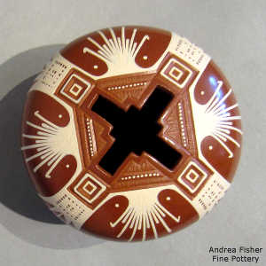 Sgraffito and painted geometric design on a red and white jar with a geometric cut opening