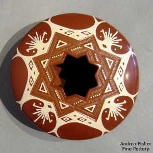 Sgraffito and painted geometric design on a red and white jar with a geometric cut opening