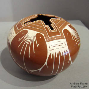 Sgraffito and painted geometric design on a red and white jar with a geometric opening
