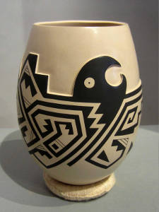 Bird, fish and geometric design on a carved and painted brown and tan jar