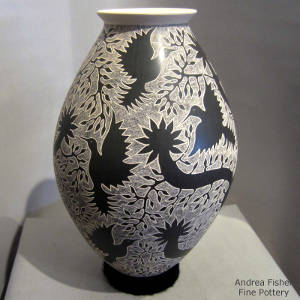 Sgraffito hummingbird and tree design on a black and white jar