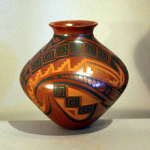 Sgraffito and black paint geometric designs on a red jar