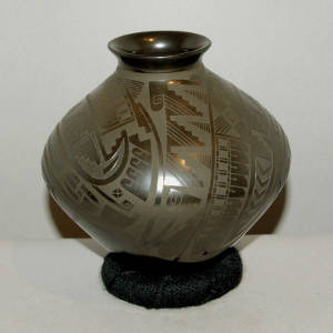 Sgraffito and painted geometric design on a black on black jar