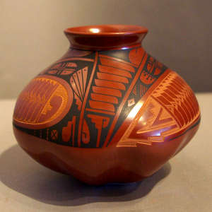 A sgraffito and painted geometric design on a melon-ribbed polychrome jar