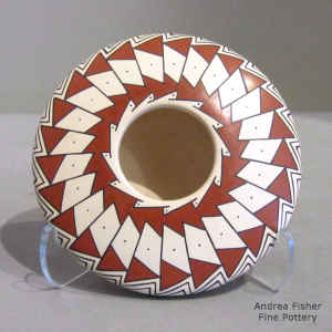 Geometric design on top of a polychrome seed pot with a turtle design on the bottom