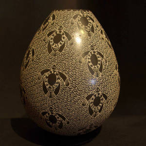 Sgraffito turtle and wave motif on a black and white jar