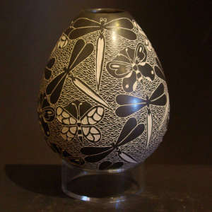 Sgraffito butterfly and dragonfly designs on a black and white jar