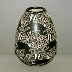 Sgraffito rabbit and geometric design on a black and white jar