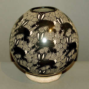 Sgraffito rabbit and geometric design on a black and white jar