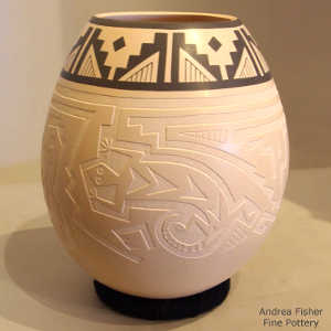 Mimbres-style lizards and a turtle lightly carved into a cream jar with a black geometric design along the rim