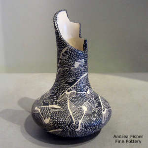 Sgraffito bird and mesh design on a black and white jar with a terrace-cut opening