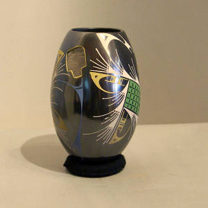 Carving and multi-colored geometric designs on a black vase
