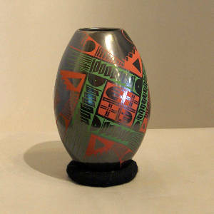 Red and green fine line and geometric designs on a black vase