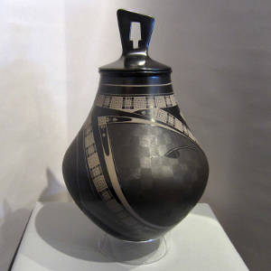 Painted geometric and sgraffito fine line designs on a lidded polychrome jar