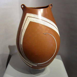 Painted geometric and sgraffito fine line designs on a polychrome jar with an organic opening