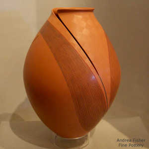 Sgraffito fine line and geometric design on a red jar with an organic opening