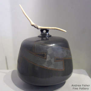 A driftwood lid and sgraffito geometric design on a black on black jar