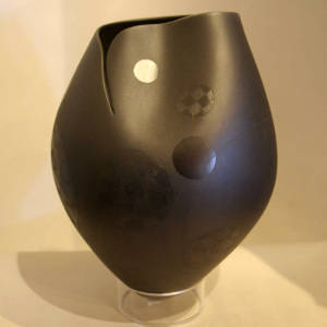 Sgraffito circles and an organic opening on a black on black jar