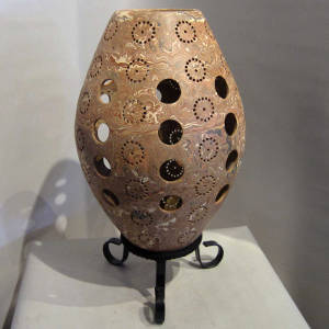 Circular cutouts and circular perforations in a marbleized clay jar
