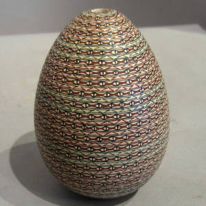 Black, green and red fine line geometric design on an egg-shaped seedpot
