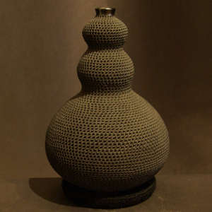 Bulges decorate a corrugated black jar