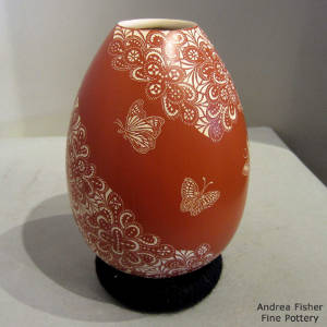 Sgraffito butterfly and geometric design on a red jar