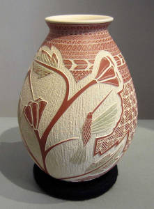 Sgraffito hummingbird, branch and geometric design on a red and white jar
