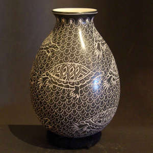 Sgraffito turtle designs on a black and beige jar