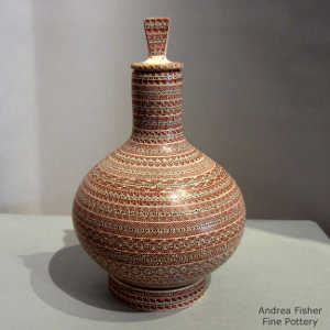 Bands of geometric design on a lidded polychrome jar with a matching stand