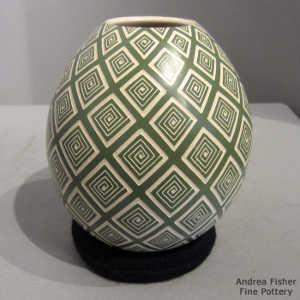 Sgraffito design on a beige and green jar