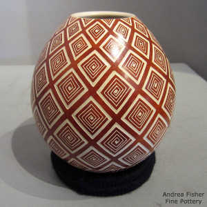 Sgraffito geometric design on a red and buff jar