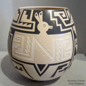 Light carving and sgraffito black outline animal motif
on a cream jar