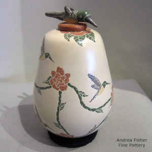Sgraffito and painted hummingbird, flower and mesh design on a polychrome jar with a hummingbird lid
