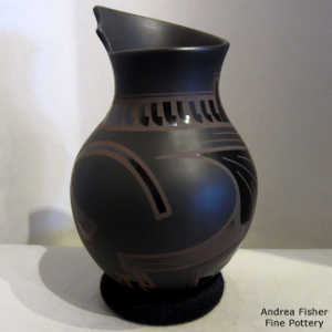 Geometric design on a black on black on black jar with an organic opening