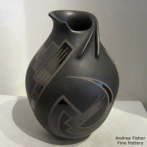 Organic opening on a black on black on black jar with a geometric design