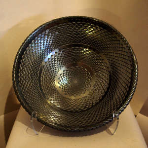 A basket weave design carved into a large graphite black bowl