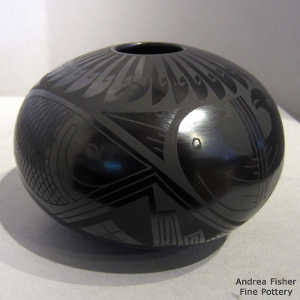 Parrot, fish and geometric design on a black on black jar