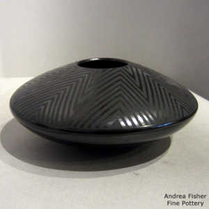 Geometric design on a black on black flying saucer jar