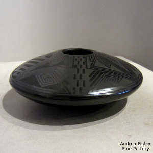 Shard geometric design on a black on black flying saucer jar