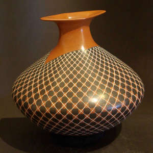 Black and white geometric design on a red jar with a diamond-shaped lip