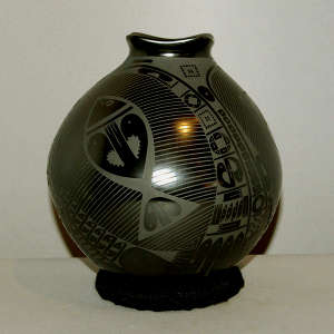 A fish and geometric design on a black on black jar with a squared lip