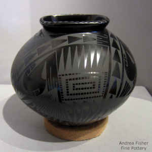 Black on black jar with a geometric design and corrugated square rim