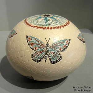 Sgraffito and painted butterfly and geometric design on a polychrome seed pot