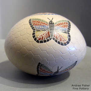 Sgraffito and painted butterfly and geometric design on a polychrome seed pot