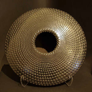 Textured surface and corrugated opening on a black flying saucer jar