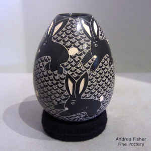Sgraffito rabbit and mesh motif on a black and white jar